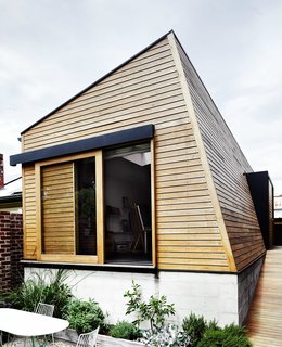 An angular new outbuilding fills the footprint of what was once an inground swimming pool, completing an awkward corner at the back of the site. 