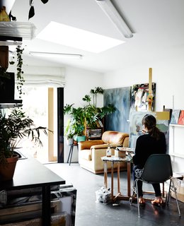 Its timber shiplap cladding tops a concrete blockwork base. Kate uses the main floor as an art studio, where light through a custom skylight illuminates her work space. 