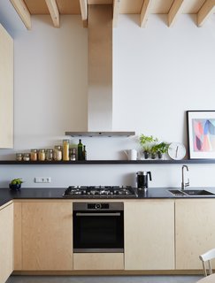 The birch plywood cabinets, designed by Jeffries, are paired with engineered wood countertops by Valchromat and appliances by Bosch. 