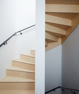 The same wood used in the kitchen appears in the exposed timber staircase and in the bathrooms. 