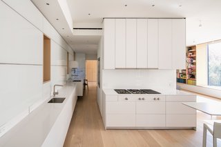 These 30 White Kitchens Are Anything But Ordinary - Photo 1 of 30 - A cooktop and refrigerator from Gaggenau, Bulthaup cabinets, a Miele oven, and an Asko dishwasher outfit the all-white kitchen, which is located on the entry-level floor.
