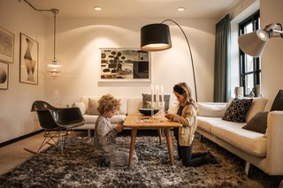 She replaced the existing windows with custom JVK Vinduer designs, but could not alter the shape or size of the apertures. A VP Globe lamp by Verner Panton hangs from a corner of the living room, illuminating an RAR rocker by Charles and Ray Eames for Vitra.