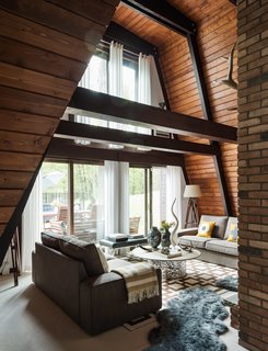 One Couple's Imagination Goes Wild at a 1967 Weekend Retreat - Photo 6 of 12 - Original tongue-and-groove pine boards, restained a warm chestnut hue, run horizontally to the ceiling. The residents layered gray sheepskin rugs on top of wool berber carpeting, installed by Joseph Velletri’s Sons. 