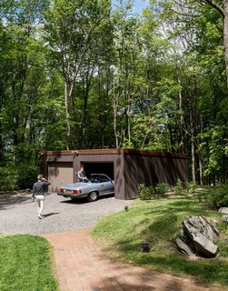 One Couple's Imagination Goes Wild at a 1967 Weekend Retreat - Photo 8 of 12 - For the garage, the couple replaced rotted timbers, swapped in new gutters, and stained the exterior Cordovan Brown by Benjamin Moore to match the home and pool house. 