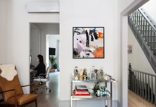 Modern Becomes Eclectic in This Renovated Brooklyn Townhouse - Photo 2 of 13 - Lyons works in her home office sited between the kitchen and the living room. A 1970s chrome bar cart stocked with vintage decanters sits near a leather-and-teak armchair by mid-century Danish designer Søren J. Ladefoged that Lyons inherited from her family. 