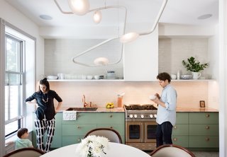 Modern Becomes Eclectic in This Renovated Brooklyn Townhouse - Photo 5 of 13 - The couple’s bold mix-and-match sensibility applies most unconventionally to the material palette; nearly every surface is different from the next. The cook station pairs a copper Watermark faucet with an Italian marble countertop, a copper-toned stainless-steel range from Blue Star, and a backsplash of masonry Foundation Brick tile by Ann Sacks. 