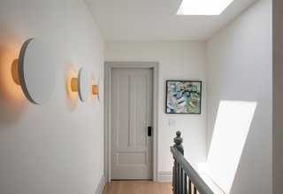 Modern Becomes Eclectic in This Renovated Brooklyn Townhouse - Photo 7 of 13 - A series of Radient sconces by RBW illuminates the third-floor landing with a subtle graphic pop.