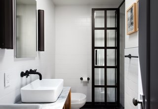 Modern Becomes Eclectic in This Renovated Brooklyn Townhouse - Photo 10 of 13 - An austere palette defines the master bathroom, with subway tiles from Classic Tile New York, matte-black fixtures by California Faucets, and black perforated-aluminum Branch sconces by RBW.