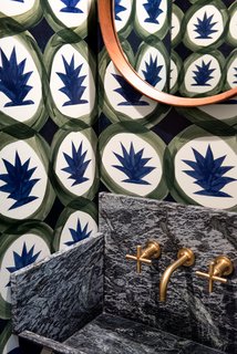 Modern Becomes Eclectic in This Renovated Brooklyn Townhouse - Photo 11 of 13 - The tiny powder room is outfitted with a foliage-print wallpaper from Hermès, a vintage teak mirror, brushed-fold Moderne fixtures from Kohler, and a custom sink made of swirling soapstone.