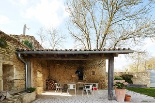 Over a Decade, Two Furniture Designers Reimagine a 300-Year-Old Barn - Photo 10 of 11 - On the terrace, Air chairs by Jasper Morrison for Magis surround an oak table with black trestle legs. The limestone used to build the original structure was sourced from a quarry less than a half-mile away. 