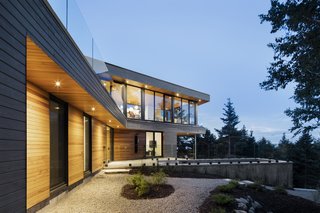 The house is finished in a gray wood facade while the roof or most private areas of the home are covered in western cedar. The cedar extends into the interior for continuity. 