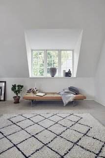 A PK80 bench is opposite of the coffee table and sofa. 