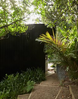 Seeking a private escape from busy Auckland life, Milton Henry and Mark Summerville purchased an "unbuildable" lot on Waiheke Island and then rehabbed it over 15 years. A clearing in the bush dictated the footprint,resulting in two stacked volumes that form a tower-like structure over four split levels. It took a customized trailer to bring materials to the steep site.