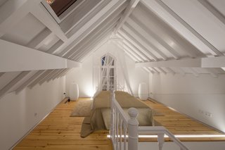 This Revived 19th-Century Home Keeps Its Character Even With a Minimalist Interior - Photo 5 of 6 - The bedroom on the top floor features exposed beams and minimal furnishings. 