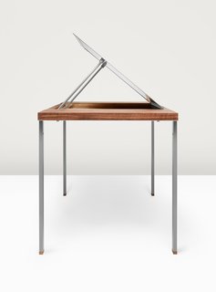 What if Furniture Worked Like a Swiss Army Knife? - Photo 3 of 3 - Adjustable legs, inspired by the pocketknife’s slender housing for tookpicks and tweezers, elevate the Convertible Table from coffee table to desk height. A metal panel that rises from the walnut surfaces reveals a one-and-a-half-inch-deep compartment that acts as a drafting board. 