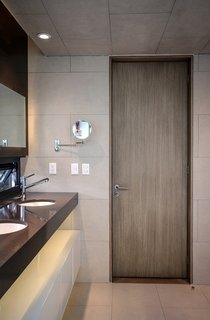 The door is made of MDF panels attached to a wood frame and topped with an ash veneer. The tiles are from Spanish brand Vives. 