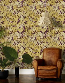 The deep golden yellow, cream, and beige leaves on this Aja (Aubergine) wallpaper—designed by Justina Blakeney for Hygge & West—gives this room a luxe, modern feel.