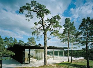 The matte black exterior and floor-to-ceiling glass of Villa Överby sit flush on limestone slabs.