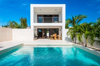The open-plan living area looks out to an intimate courtyard with an infinity pool. 