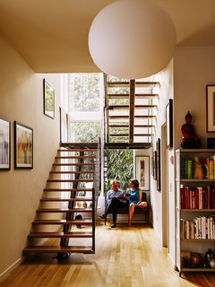 Louis did much of the woodworking in the house, including the fabrication of the white oak stair treads. The ironwork was crafted by Alex and Gio Welding. A Glo Ball pendant by Jasper Morrison for Flos hangs in front of the staircase.