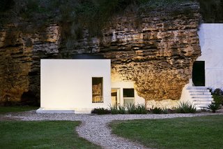Ever Wanted to Stay in a Cave That’s Actually Pretty Modern Inside? - Photo 2 of 10 - Designed by Spanish architectural practice UMM Estudio, House Villarrubia sits on the foothills of Sierra Morena in a sloping calcarenite terrain. The only cave house in Cordoba, its interiors comprise of clean, quiet volumes, glass apertures, and handcrafted wooden furniture. It's available for rent through Airbnb. 