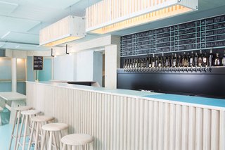 The custom-made bar, tables, benches, and lights were created by Kristian Lillelund of carpentry studio Rum4. 