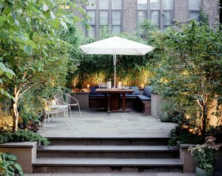 Elysian Landscapes modernized a classic brownstone by creating a private bi-level patio with clean, built-in seating for outdoor dining.