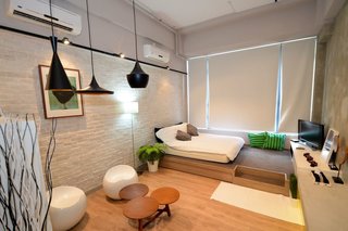 10 Modern and Stylish Places to Stay in Hong Kong - Photo 10 of 10 - With a double bed on a raised wooden platform, white-washed brick walls, and Tom Dixon pendant lights, this 313-square-foot studio apartment is perfect for single travelers or couples. 