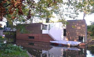 Anchored beside a wooded parkland, this houseboat in the Netherlands was designed by BYTR Architects.