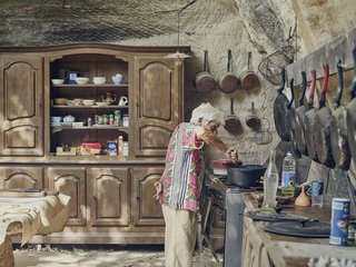 In the limestone kitchen embedded in the hillside, Lolo keeps only proven essentials—skillets that have been seasoned countless times and furniture that has been passed down for generations. 