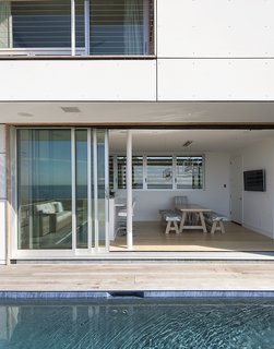 Having a strong outdoor element was also important. <br>A 32-foot-wide Solar Innovations sliding door connects the kitchen <br>to a deck and pool. 