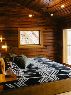 An Eclectic Pacific Northwest Cottage - Photo 3 of 13 - The master bedroom’s <br>custom bed has built-in storage. The lighting is by Workstead.