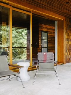 An Eclectic Pacific Northwest Cottage - Photo 9 of 13 - Sling chairs by Garza Marfa flank <br>a Made Goods concrete table.