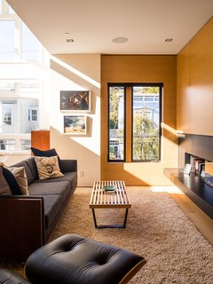 In the living area, a restored Milo Baughman sofa and a Nelson Platform bench join an Ortal fireplace. 