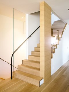 The staircase follows the bedroom's new primary material, French white oak. 