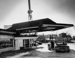 The building features a cantilevered copper canopy and is primarily made of concrete, glass, and steel. There's a glass observation lounge on the second floor for community interaction. Cypress, one of Wright's favorite materials, is used throughout the interior. Photo circa 1963.