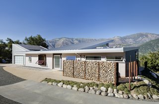 Solar panels are affixed to the garage roof, which is angled to maximize exposure. 