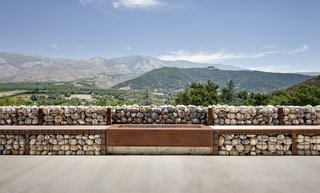 The gabions hold smooth rocks from the nearby San Luis Rey River; a fireplace feature is flanked by benches. 