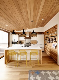 Swell lights by Pablo hang above Hot Mesh stools from Blu Dot. The millwork is by J. Spix Fine Cabinets.