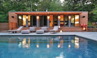 This pool house in Connecticut was fashioned from two shipping containers, bedecked in well-lit cedar, which contrasts beautifully with the blue of the water.