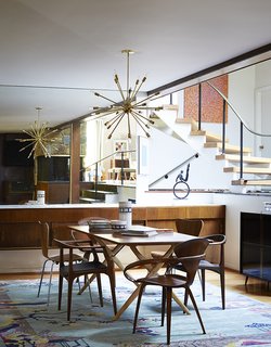 Mostly they restored original elements, like the buffet and the staircase. Cherner chairs sit at the head of a Design Within Reach table. The armless Series 7 chairs are by Arne Jacobsen; the third pair are Juliana chairs by Aristeu Pires.