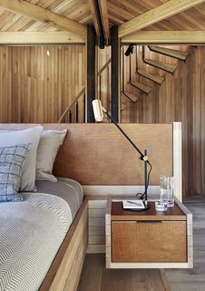 Like the built-in bed, nightstands, headboard, and other custom furniture, the staircase leading to the open-air viewing platform was made by Versfeld. The Lektor desk lamps are by Rubn. 