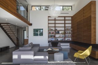 Jay and Jaclyn Lieber worked with Erla Dögg Ingjaldsdóttir and Tryggvi Thorsteinsson of Minarc to design a house using the designers’ mnmMOD panels, which can be assembled with a screw gun. The core of the home was kept open to maximize natural light. Clerestory windows, walnut cabinetry, and concrete floors define the living room, which features a sectional by Jessica McClendon of Glamour Nest, who consulted on the furnishings, a Nesta rug from Design Within Reach, a Moooi Random Light from YLighting, and Hecks ottomans from Blu Dot. 