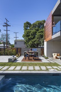 Working with contractor Mike Stayer of Core Construction, the designers created an indoor/outdoor environment for the family. The kids hang out while Jaclyn helms the grill from Barbeques Galore. The Eos Collection dining set is from Design Within Reach. An Element coffee table from CB2 occupies the covered patio. 