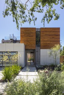 The designers used wood sparingly for maximum effect, like the cedar siding on the front and back exteriors. The main facade offers a glimpse through the house to the backyard, which was made larger by placing the garage closer to the street. "We hosted a concert and had people sitting inside and in front of the pool," says Jaclyn. "The house completely lends itself to entertaining small and large groups alike." 