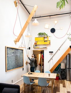 Max devised a movable plywood beam that holds a trio of pendant lamps to swing down as needed. A wood piece covered in chalkboard paint hides the electrical panel. "Slate was too expensive," he says. 