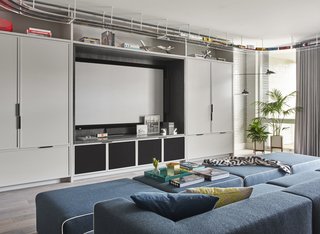 In addition to the triplex’s first-floor movie room, there is a rooftop theater with a miniature golf course. A custom sofa and ottomans are upholstered in felted wool by Maharam.
