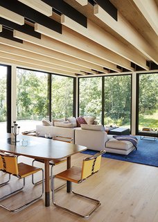 In the dining area, a custom table by interior designer Elizabeth Bolognino is surrounded by Spoleto chairs by Knoll.