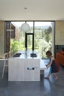 A custom table designed by Jones features a pull-out bench on one side and 1C dining chairs by Room B on the other; the Globo pendant is by Viso.