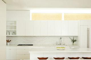 The kitchen is defined by Olympian White Danby marble counters and a backsplash by Stone Source. The Tractor stools are by Craig Bassam for BassamFellows. 